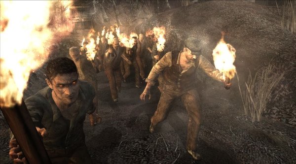 Resident Evil 4 (2005) screenshot: A group of villagers holding torches advance on a dark, forested path.