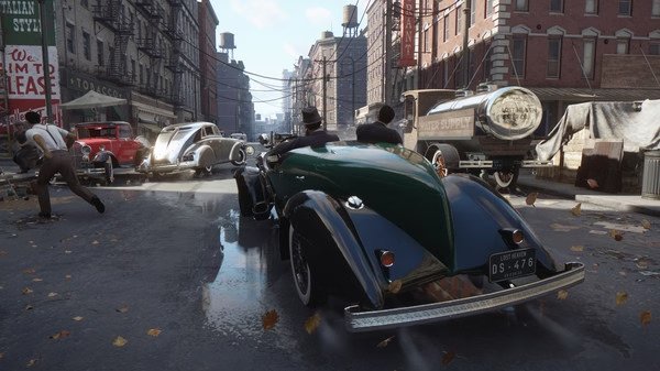 Screenshot from Mafia: Definitive Edition showing a vintage green car driving through a bustling city street with various other vehicles.