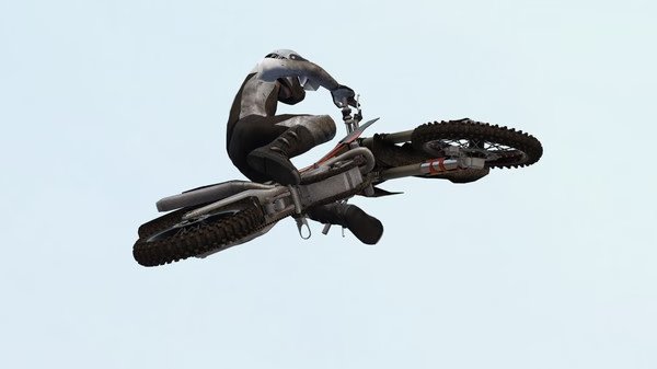 MX Bikes screenshot: A motorcyclist performs a high-flying stunt, showcasing dynamic action against a clear sky background.