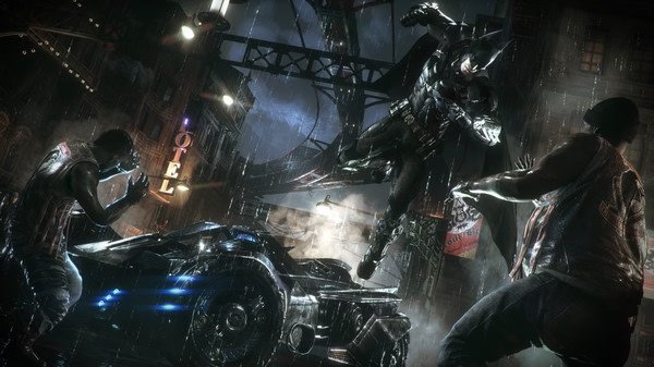 Batman: Arkham Knight screenshot. Batman leaps in a rainy street, facing two foes beside the Batmobile.