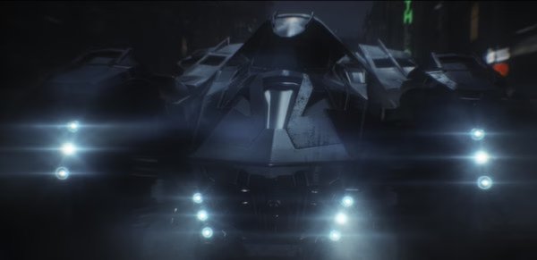 Batman: Arkham Knight screenshot showing the Batmobile illuminated by bright lights in a dark city setting.