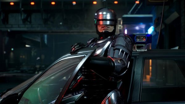 Screenshot from RoboCop: Rogue City showing RoboCop leaning on a patrol car in a dimly lit urban street scene.