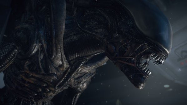 Screenshot from Alien: Isolation showing a close-up of a menacing Xenomorph with its mouth open in a dark, eerie environment.