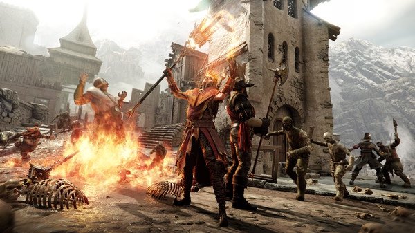 Warhammer: Vermintide 2 screenshot showing heroes battling Skaven and Chaos enemies in a fiery medieval village setting.