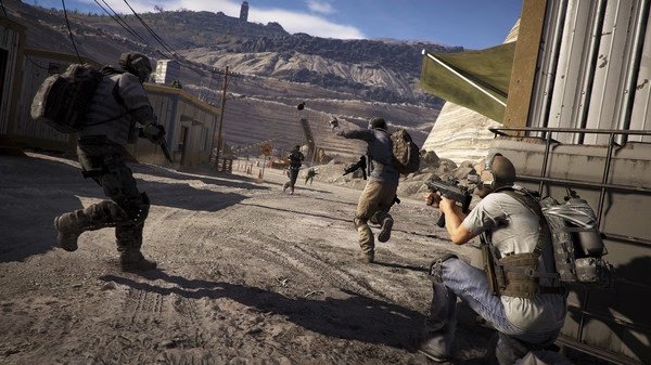 Soldiers engage in a desert firefight in this 'Tom Clancy's Ghost Recon Wildlands' screenshot, with mountains in the background.