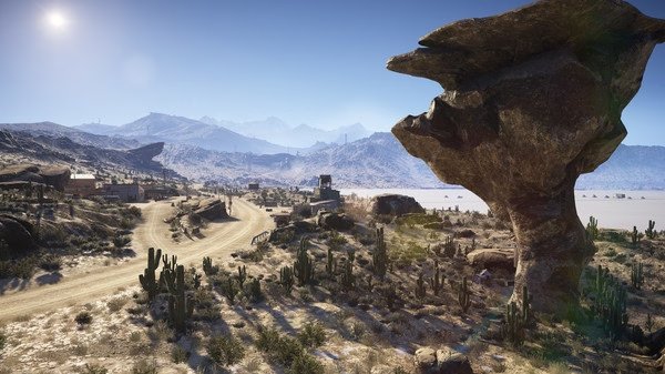 Screenshot from Tom Clancy's Ghost Recon Wildlands showing a rocky desert landscape with cacti, a dirt road, and distant mountains.