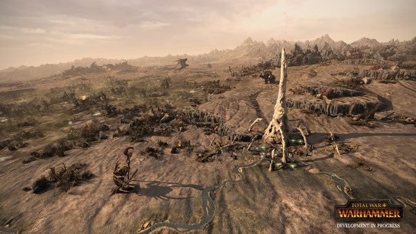 Screenshot from Total War: WARHAMMER showing a desert landscape with a large, spiral structure and scattered armies.