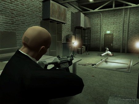 Hitman: Blood Money screenshot: Agent 47 aims a gun at a target in a dimly lit, industrial-style room.