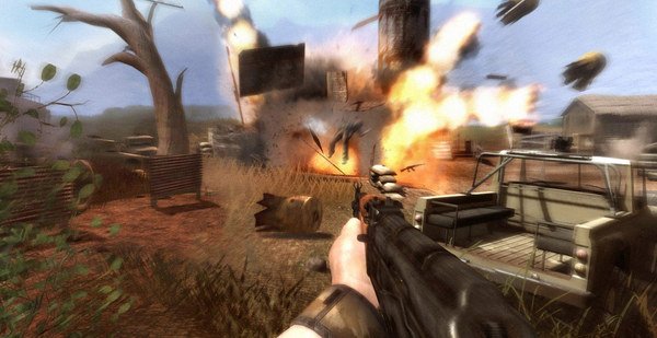 Far Cry 2 screenshot showing a first-person view of a gun aimed at an explosion in a rural area with scattered structures and trees.