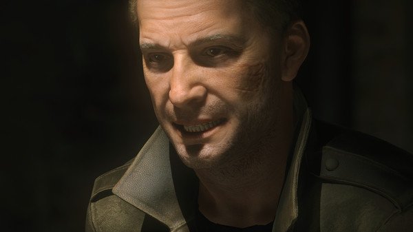 Screenshot from Rise of the Tomb Raider showing a character in a dark jacket, with a dimly lit, shadowy background.