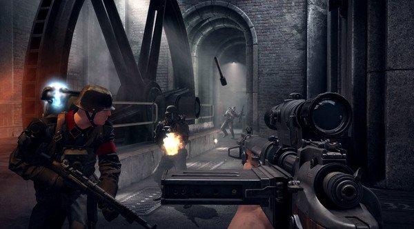 Screenshot from Wolfenstein: The Old Blood showing a player aiming a rifle at enemies in an industrial tunnel setting.