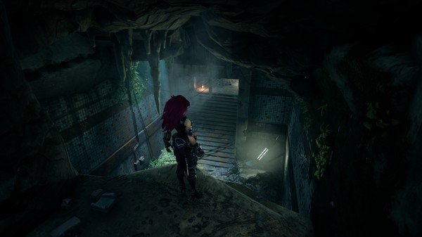 Darksiders III screenshot: A character with red hair stands poised in a dimly lit cave tunnel, surrounded by stone and vegetation.