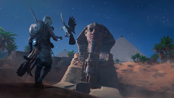 Screenshot from Assassin's Creed Origins showing a character interacting with a bird in front of a sphinx at night.