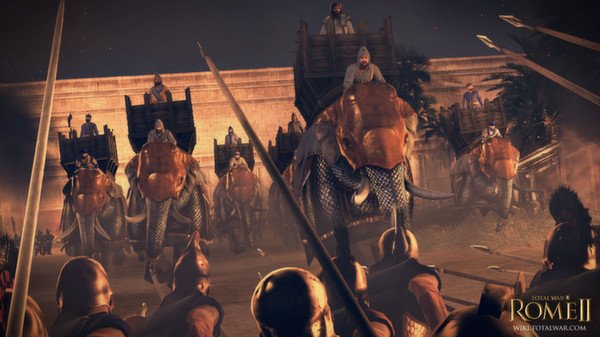 Screenshot from Total War: Rome II - Emperor Edition showing soldiers facing a charge of armored war elephants near a large stone wall.