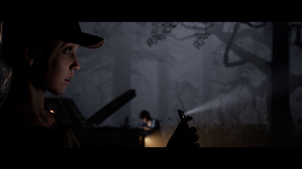 The Quarry screenshot: A person in a cap holding a phone in a dark forest, with another person near a car in the background.