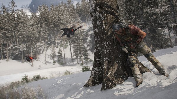 A screenshot from Tom Clancy's Ghost Recon Breakpoint shows a soldier hiding behind a snowy tree as drones patrol the forest.
