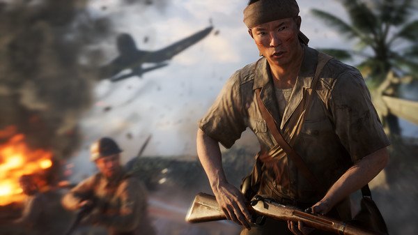 Screenshot of Battlefield V showing a soldier in combat gear holding a rifle, with explosions and aircraft in the background.