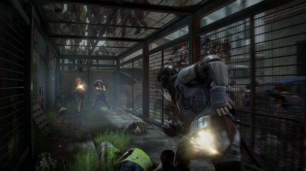 World War Z screenshot: Players battle zombies in a fenced corridor, with one character firing a weapon amidst the chaos.