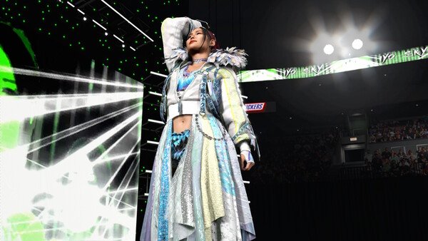 A WWE 2K26 screenshot showing a wrestler in a detailed outfit posing confidently on the stage under bright lights.