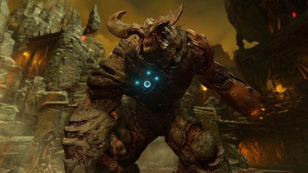 A DOOM screenshot showing a towering demon with glowing blue symbols on its chest in a fiery, desolate environment.